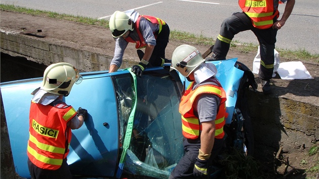 Hasii vyproují automobil napasovaný v koryt potoka ve zlínské ásti Louky.