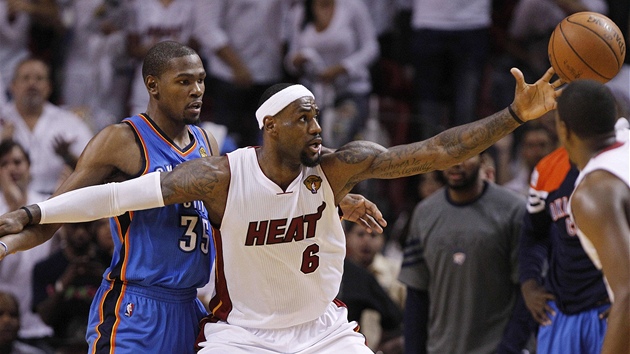 DOSÁHNU TAM?  LeBron James z Miami Heat se natahuje po mí�i, brání ho Kevin