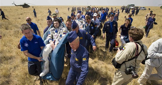 Trojice kosmonautů po přistání v kazašské stepi (1. července 2012)