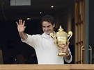 TOHLE JE ONA. Roger Federer mává divákm z balkonu ve wimbledonském areálu se