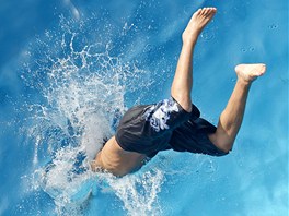 Mladík skáe do bazénu v Erfurtu, aby se svlail v letních vedrech. Nmecko si...