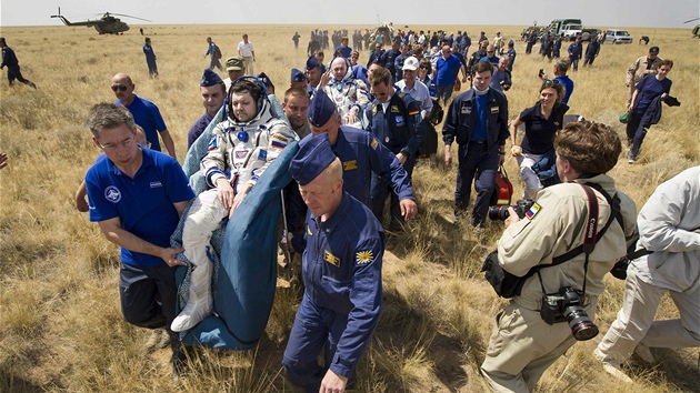 Trojice kosmonautů po přistání v kazašské stepi (1. července 2012)