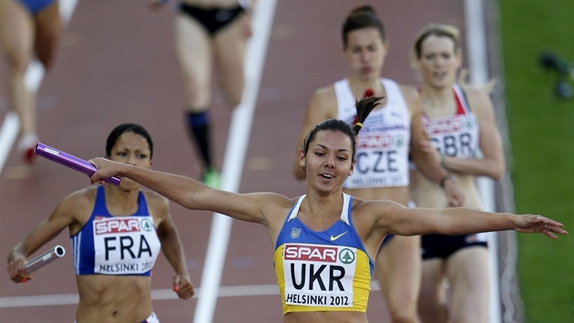 V CLI. Ukrajinka Alina Lohvynnkov se v cli tafety na 4x400 m raduje, uhjila pro svou zemi zlato. V pozad dobh na tetm mst Denisa Rosolov.