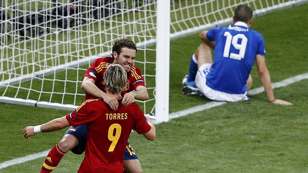 TO UŽ JE DEBAKL. Zatímco Španělé Mata a Torres slaví čtvrtou branku ve finálovém utkání, italský stoper Bonucci zklamaně sedí na brankové čáře.