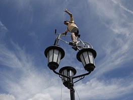 AKROBAT. Fanouek balancuje s kolem na vysoké lamp bhem jedenácté etapy Tour...