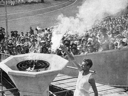 HOÍ. Britský atlet John Mark zapaluje olympijský ohe na stadionu ve Wembley.