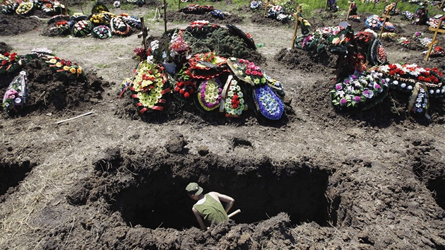 Voják kope hrob pro jednu z obtí, které nepeily povodn ve mst Krymsk (10.