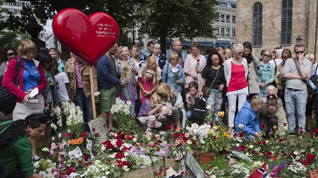 Lid nos kvtiny ped katedrlu v Oslu, aby uctili pamtku obt toku Anderse Breivika. (26. ervence 2011)