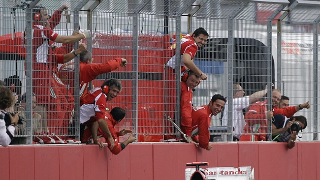 GRATULACE. Fernando Alonso projd clovou rovinkou okruhu v Hockenheimu a tmov mechanici mu gratuluj. 