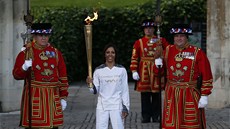 Bývalá britská b�kyn� Kelly Holmesová s olympijskou pochodní mezi strá�ci