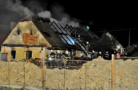 Hasiči bojují s požárem domu v Tymákově.    