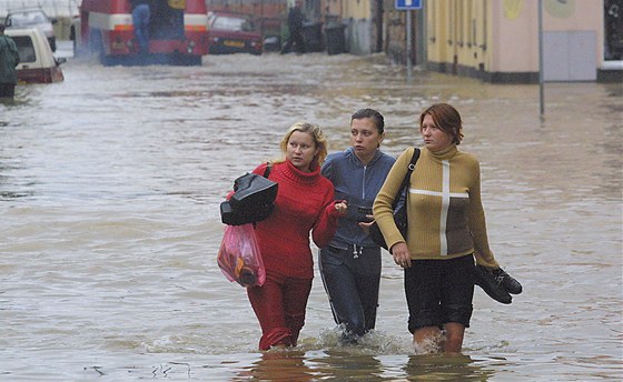 Dívky se brodí zatopenými ulicemi v plzeské tvrti Roudná. Ta pi povodni v