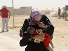 Syrská ena s díttem se kryje ped prachem v jordánském uprchlickém táboe