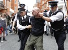 Brittí policisté odvádí jednoho z protestujících od ekvádorské ambasády v