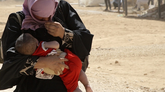 Syrsk ena s dttem se kryje ped prachem v jordnskm uprchlickm tboe (13. srpna 2012)