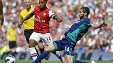 ÚTONÁ AKCE. Theo Walcott z Arsenalu se snaí pejít pes Carlose Cuellara ze