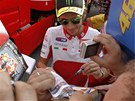 Valentino Rossi se podepisuje fanoukm v padoku.