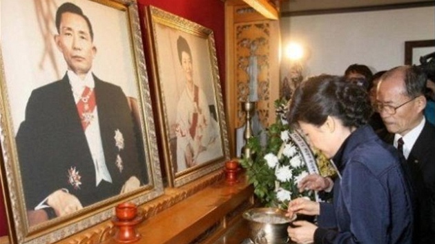 Pak Kun-hje zapaluje svci ped portrty svch zavradnch rodi (25. bezna 2008)