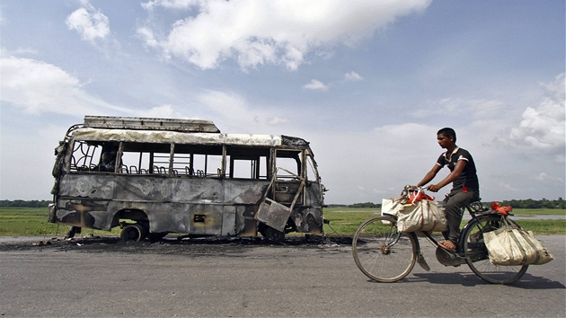 Ind jede na kole kolem autobusu splenho bhem nepokoj ve mst Rongia v severovchodn Indii (16. srpna 2012)
