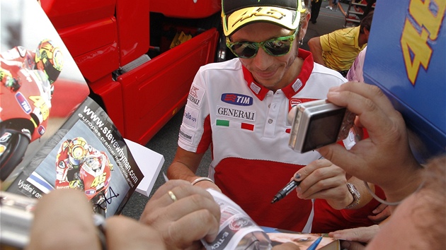 Valentino Rossi se podepisuje fanoukm v padoku.