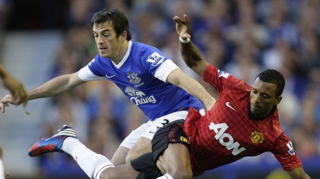 Nani (v ervenm) z Manchesteru United pad po souboji s Leightonem Bainesem z Evertonu.