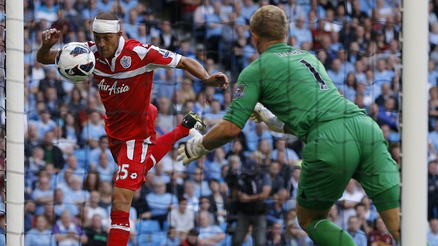 A JE VYROVNNO. Bobby Zamora z Queens Park Rangers (vlevo) hlavou dor do brny m, kter v rukavicch neudrel Joe Hart, brank Manchesteru City.