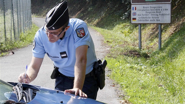 Policista si zapisuje poznmky bhem ohledvn inu u jezera Annecy (6. z 2012).