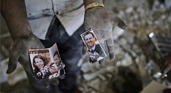 Obyvatel Aleppa ukazuje roztrenou fotografii syrského prezidenta Baára Asada