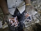Obyvatel Aleppa ukazuje roztrenou fotografii syrského prezidenta Baára Asada