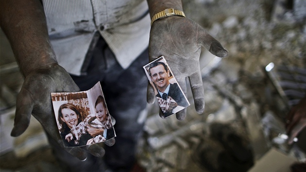 Obyvatel Aleppa ukazuje roztrenou fotografii syrskho prezidenta Bara Asada a jeho rodiny. (15. z 2012)