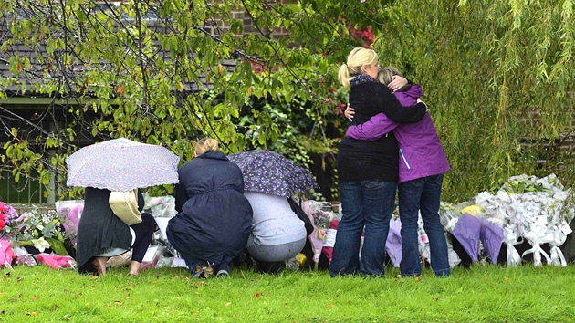 Lid z Manchesteru pinej kvtiny k mstu, kde byly ob neozbrojen policistky zabity. (19. z 2012)