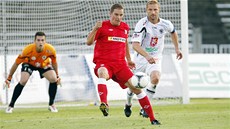 SOUBOJ VETERÁNŮ. Brněnský útočník Petr Švancara (v červeném) odehrává míč před