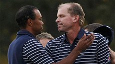 Tiger Woods (vlevo) gratuluje spoluhrá�i  Steveovi Strickerovi. 