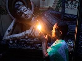 SVATÝ HNV. Bangladéská buddhistka se modlí v ruinách chrámu, který vypálili...
