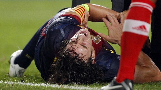 Barcelonský kapitán Carles Puyol se svíjí v bolestech. Vykloubený loket ho v