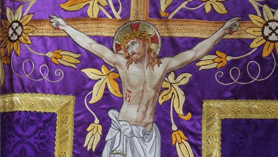 Detail ornátu s bohatě vyšívaným motivem kříže a ukřižovaného Ježíše Krista.