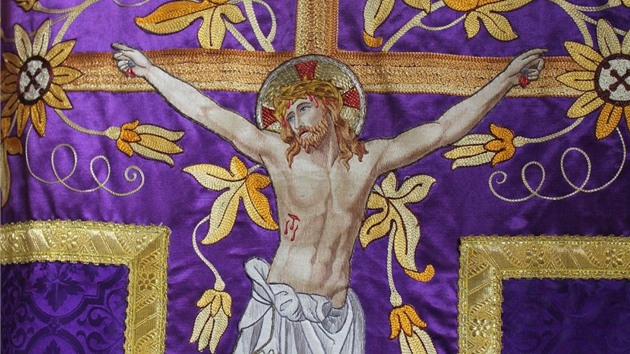 Detail ornátu s bohatě vyšívaným motivem kříže a ukřižovaného Ježíše Krista. Tento typ ornátu se nazývá kasule. Fialová barva značí, že byl používán v době postní a adventní. 