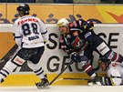 Hokejisté Liberce (v bílém) a Chomutova bojují u mantinelu o puk.