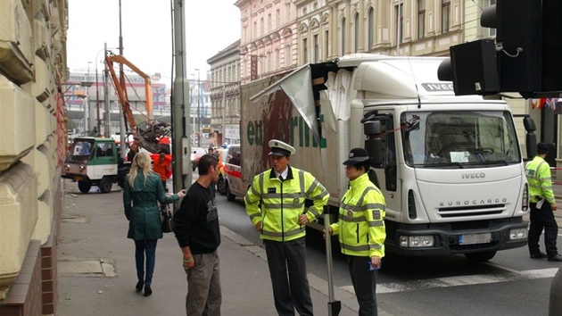 Stet nkladnho auta a vozu s vysokozdvinou ploinou na Plzesk ulici v Praze.