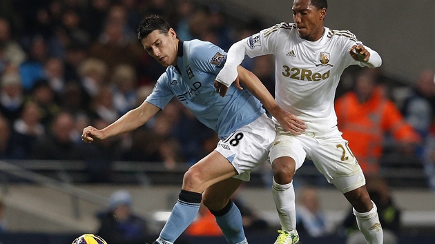 NEPUSTM T. Gareth Barry z Manchesteru City (vlevo) si kryje balon ped Jonathan de Guzmnem, fotbalistou Swansea. 