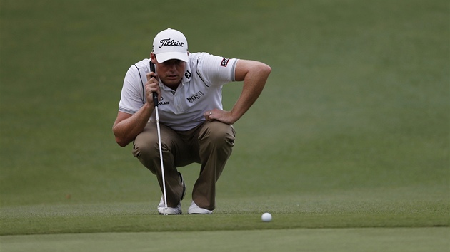 Americký golfista Nick Watney zkoumá green. 