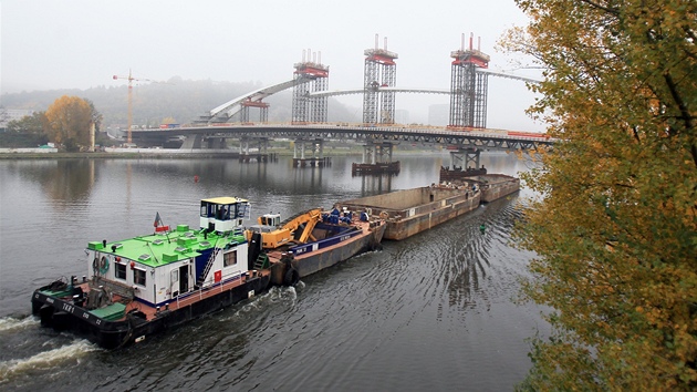 Vstavba Trojskho mostu se dostala do uniktn fze. Dlnci pomoc dutch hydraulickch lis zvedli stedn st oblouku.