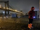 Jeden z místních obyvatel prochází zaplavenými ulicemi u brooklynského mostu.