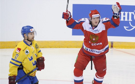 Ruský hokejista Averin slaví svojí branku proti védsku. Vlevo je zklamaný