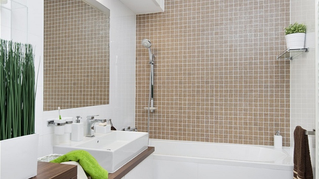 Koupelna – kombinace bílé a hnědé je nadčasová, lesklé obklady (RAKO, série Defile) dodávají prostoru luxusní charakter. Nábytek byl vyrobený na míru, drobné doplňky jsou od Sapho.
