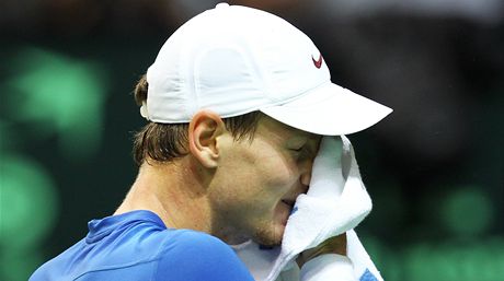 CO MU B̎Í HLAVOU. Tomá Berdych si otírá tvá runíkem, jeho výraz nevyhlíí