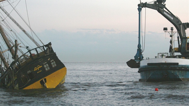 Záchranná loď bagruje písek kolem ztroskotané plachetnice La Grace. (10. 11. 2012)