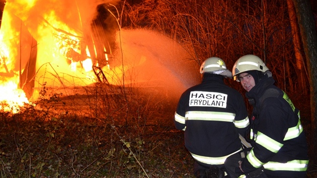Hasiči ochlazovali vodou okolí haly, aby plameny nepřeskočily na keře a stromy. (10. listopadu 2012)