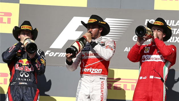KOVBOJOV NA PDIU. Zleva: Sebastian Vettel, Lewis Hamilton a Fernando Alonso po vyhlaovn vtz Velk ceny USA.