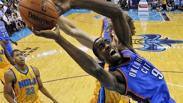 Serge Ibaka z Oklahoma City se chopil me ped doskakujcm Robinem Lopezem z New Orleans.